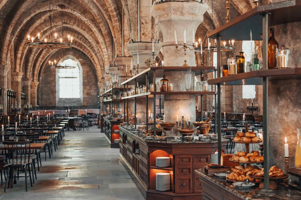 A breakfast buffet in a majestic cathedral stall hall at Abbaye des Vaux-de-Cernay.