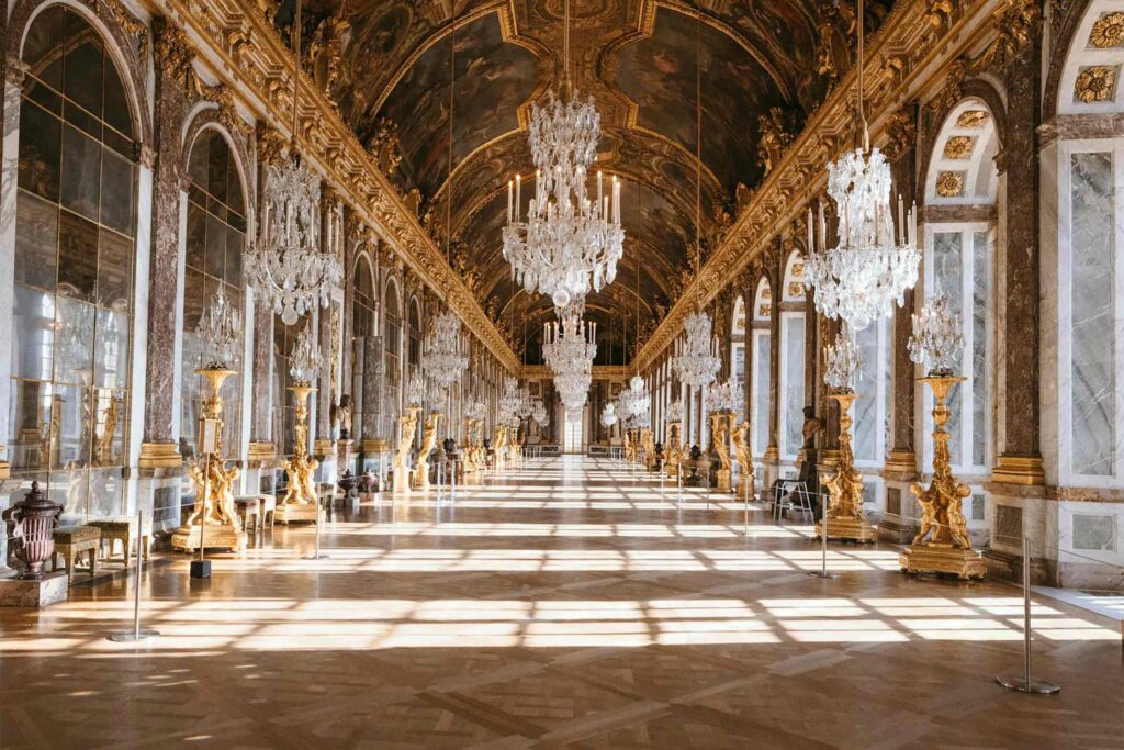 A regal ballroom with glass chandeliers at Airelles Château de Versailles - Chic stays outside of Paris.