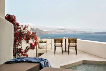 Bougainvilla strewn suite terrace with sun beds, chairs and plunge pool looking out over the Caldera at Andronis Boutique Hotel
