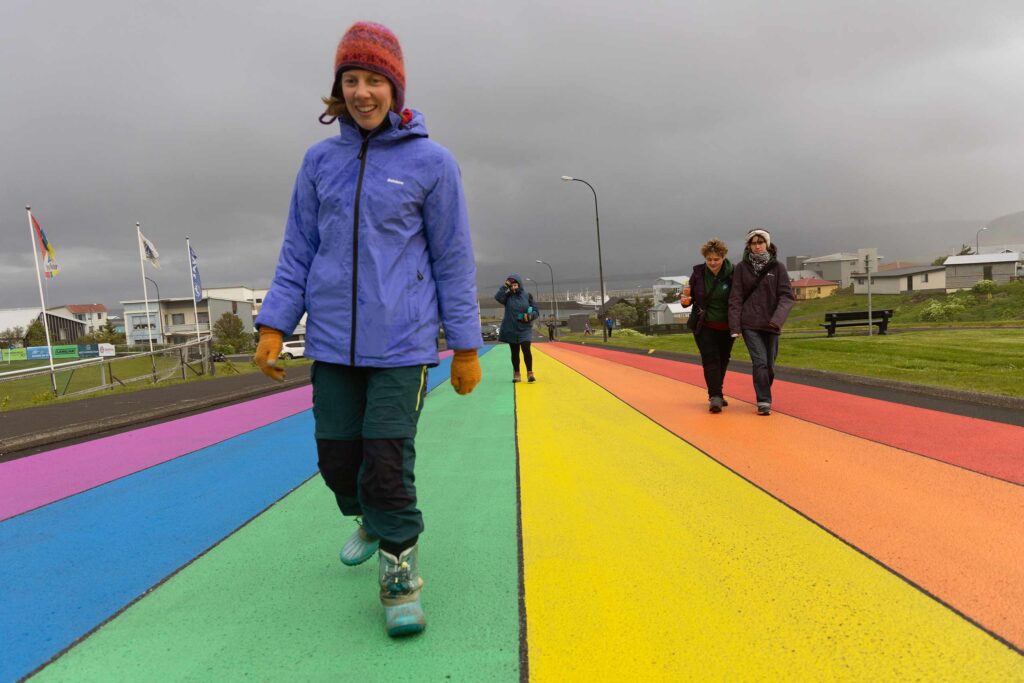 A traveller with a cognitive disability walks on a rainbow pathway on a trip with Go Beyond Holidays