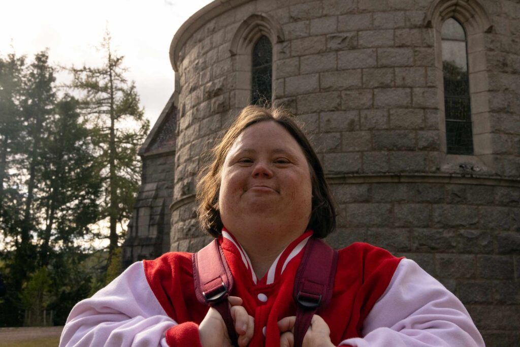 A traveller with a cognitive disability smiles for the camera on a trip with Go Beyond Holidays