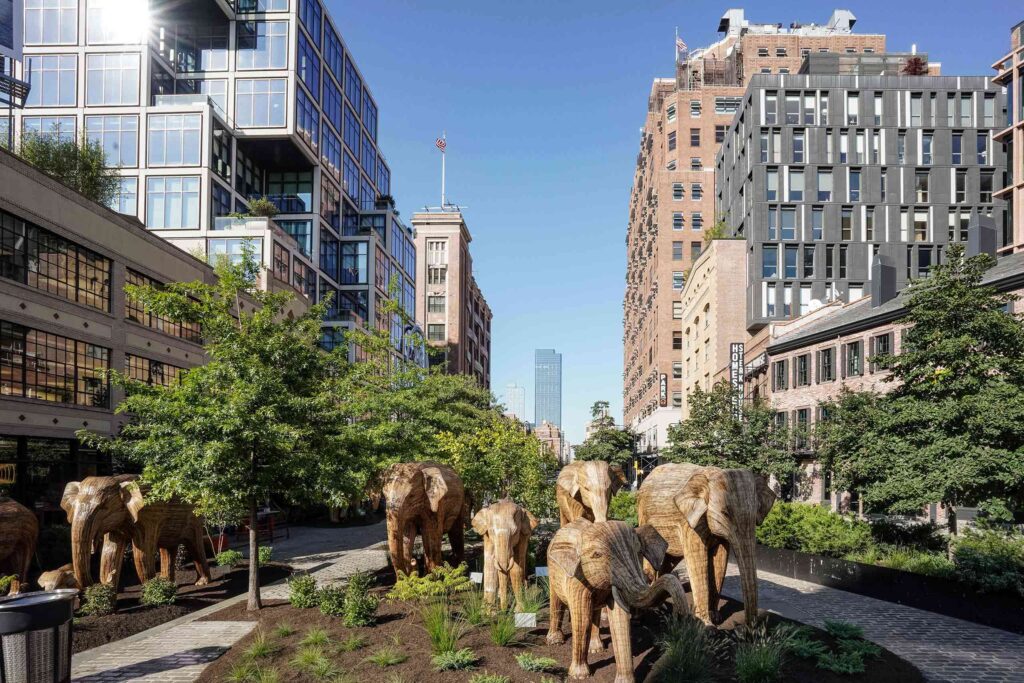 An elephant herd carved from wood in an urban park in the USA
