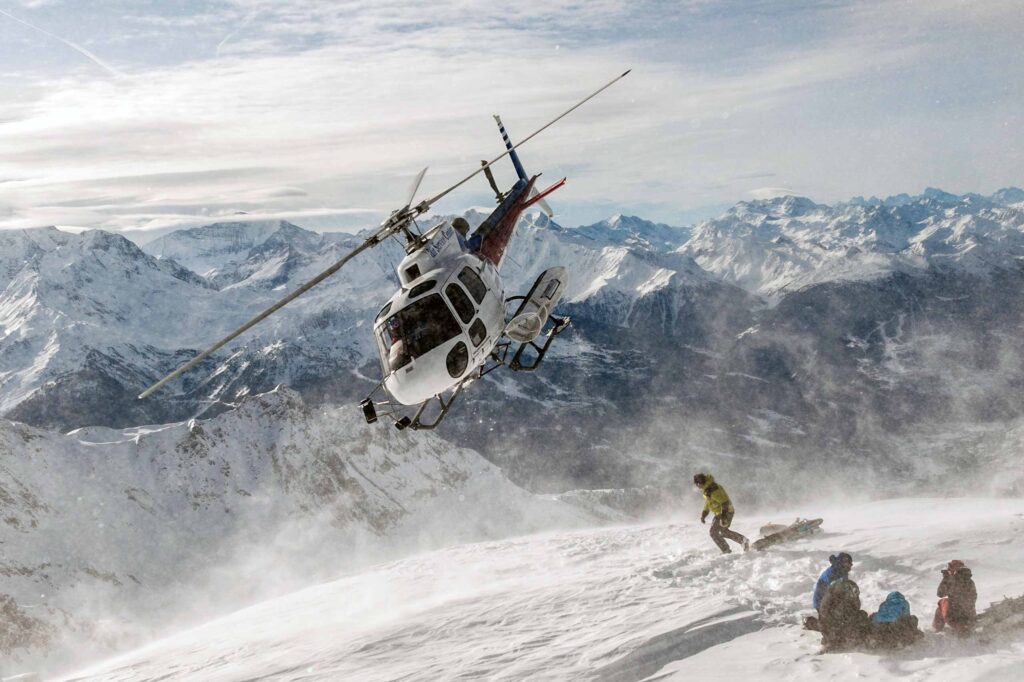 A helicopter drops off skiers during an adventure at Eleven Chalet Hibou in Le Miroir, Sainte-Foy-Tarentaise, Savoie, France