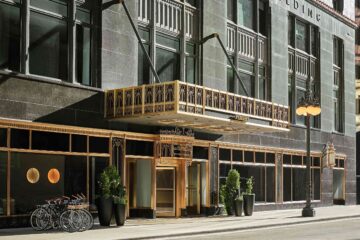 Exterior of the Carbon and Carbide Building in Chicago, now the Pendry Chicago with gilt gold trimmings, black frontage, art deco features and green terracotta tiles
