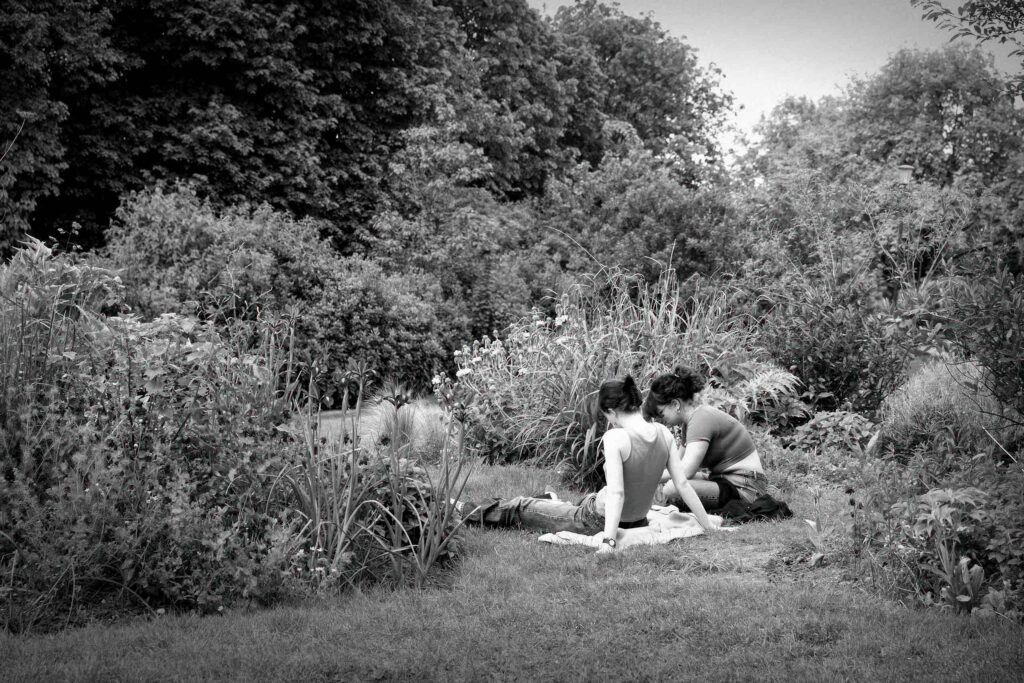 Two women sit in a park in the French capital