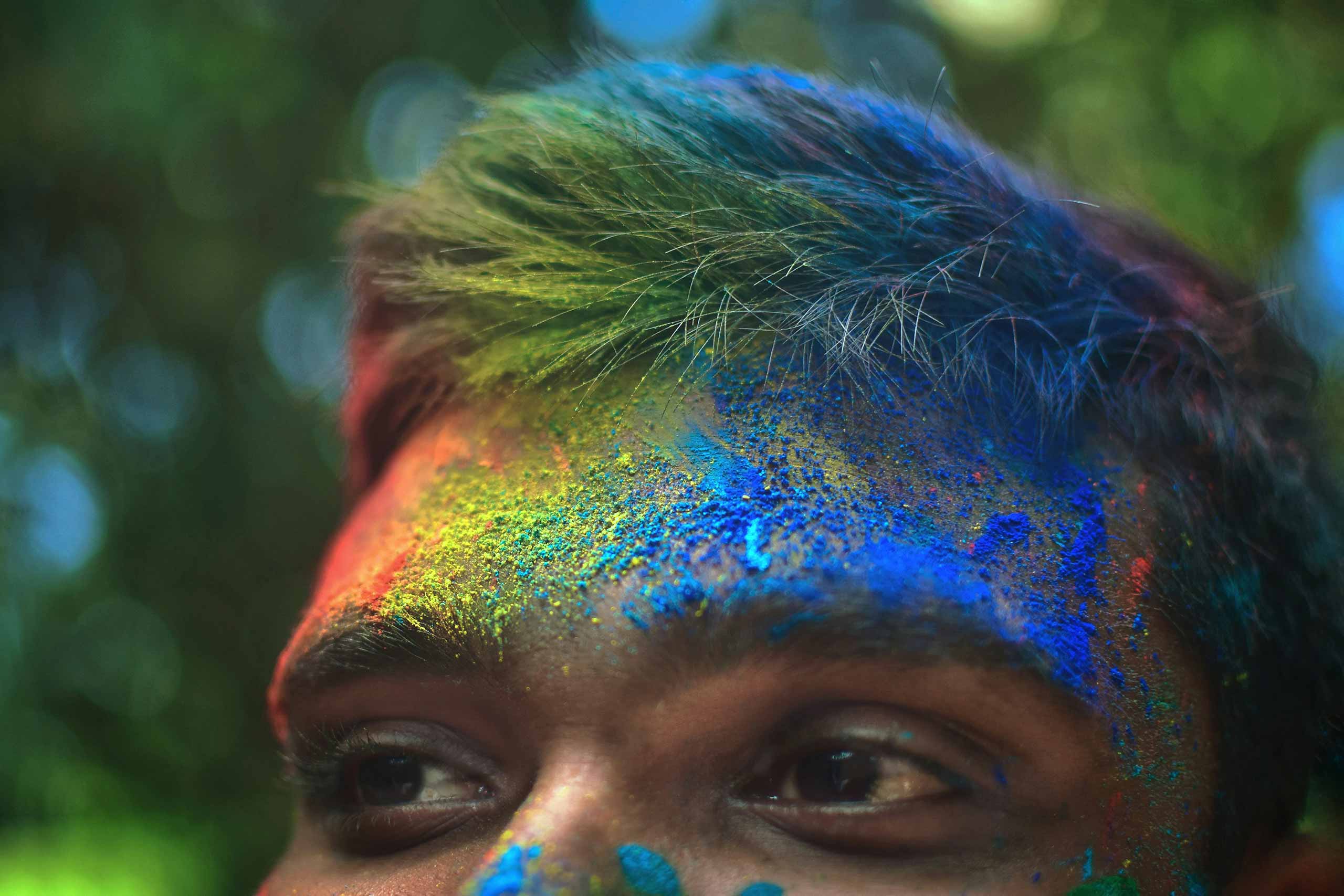 Man with rainbow glitter in his hair and face at Pride