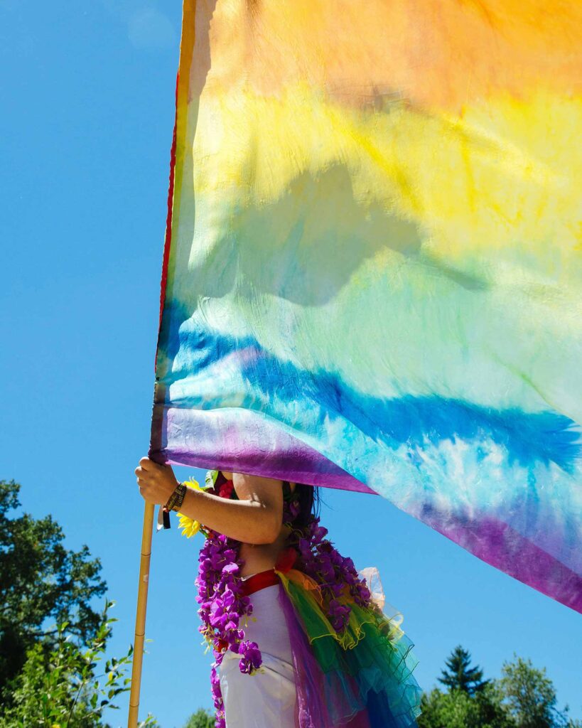 Pride reveller holding up rainbow flag for Pride Month