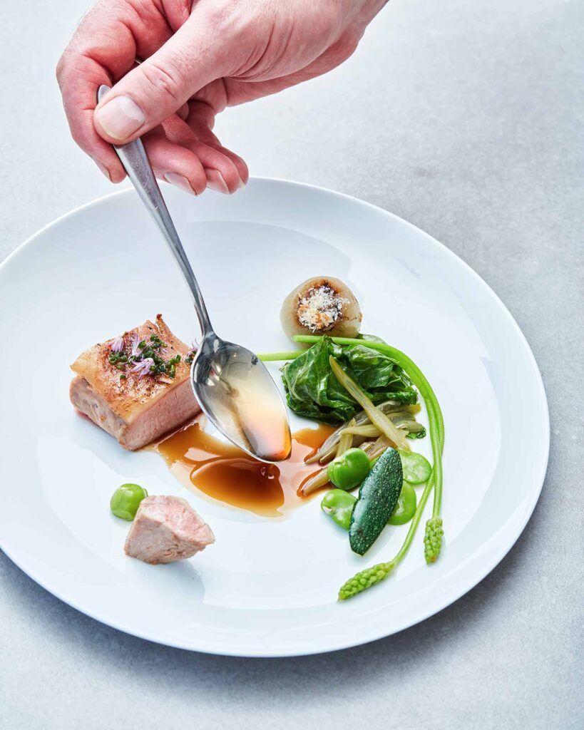 Sauce being spooned onto dish at Bij Jef in the Netherlands