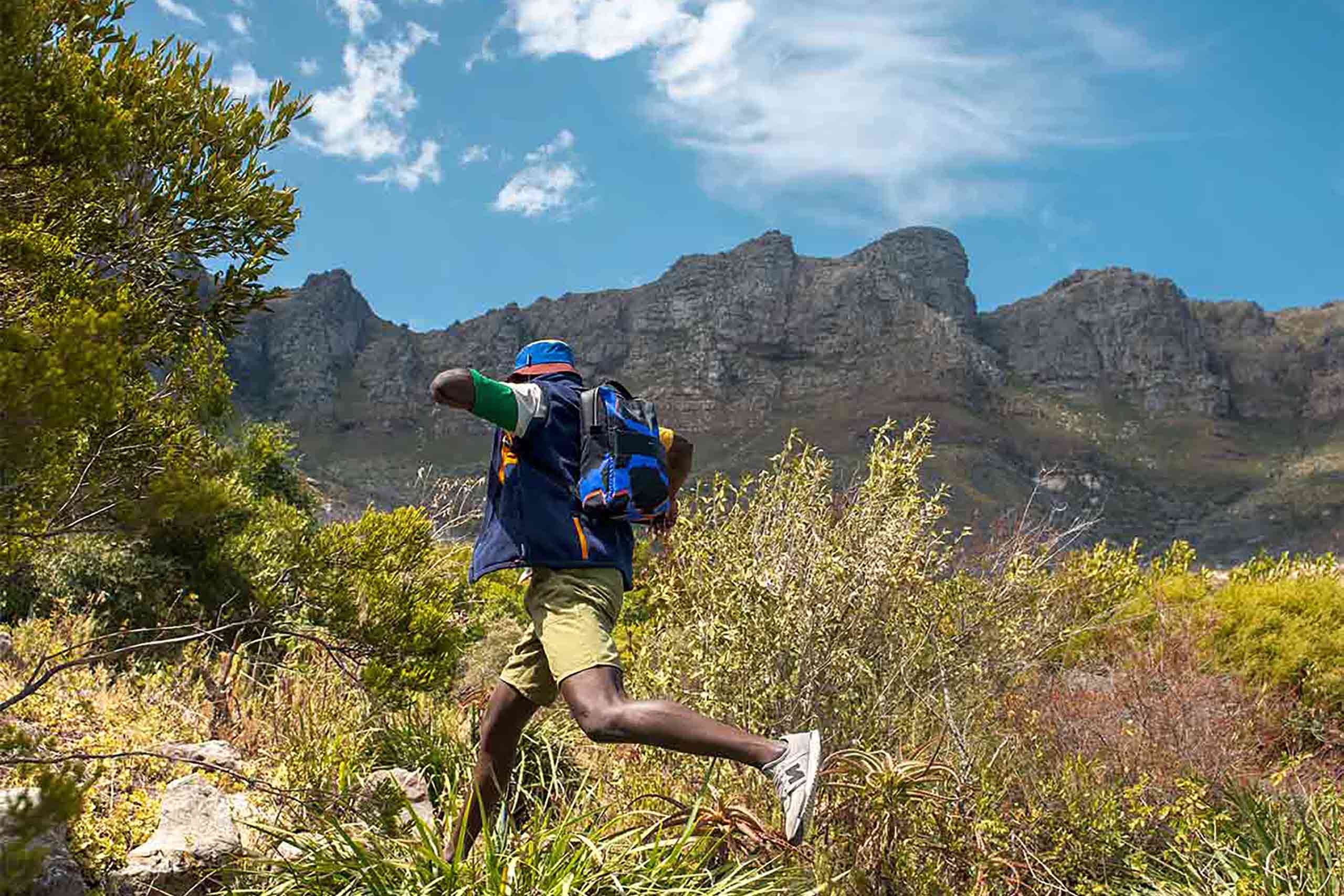 Man jumping in the foothills of Table Mountain in Cape Town, South Africa. An example of the kind of unscripted journeys we'll go on in 2025